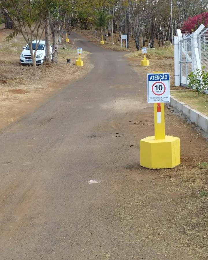 Balizador amarelo e placa de velocidade instalados em via interna
